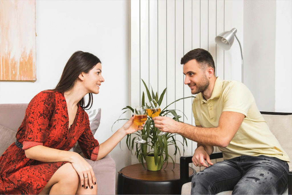 man and woman drinking wine on date at home