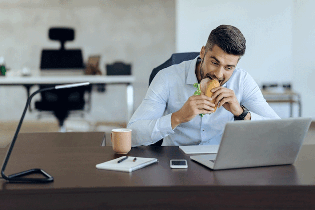 man eating lunch at desk