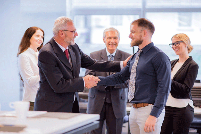 2 men handshaking and looking into each others eyes